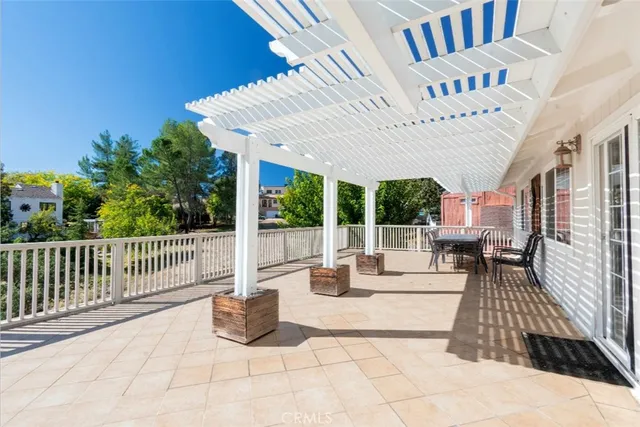 a view of a patio with a dining table and chairs with wooden floor and fence