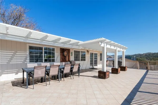 a view of a patio with table and chairs and floor to ceiling window