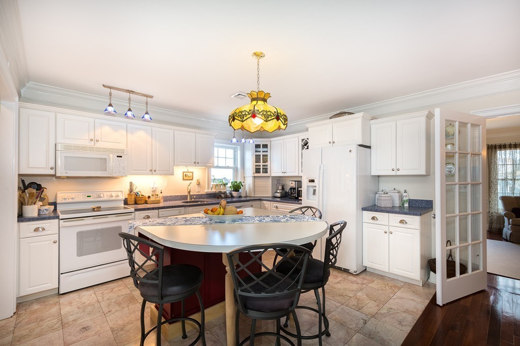 15 Park Avenue, Unit 401 Hull, MA 02045 - Photo 6 of 24 a kitchen with stainless steel appliances a dining table chairs and chandelier