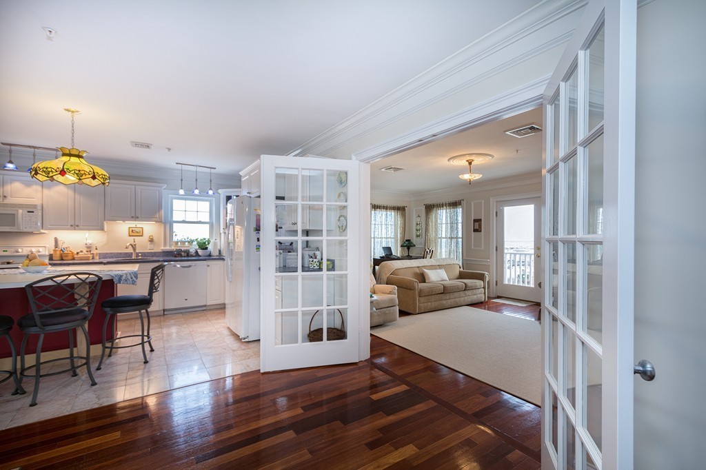 15 Park Avenue, Unit 401 Hull, MA 02045 - Photo 8 of 24 a living room with furniture and a dining table with wooden floor