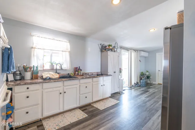 a large bathroom with a granite countertop double vanity sink a mirror and a bathtub