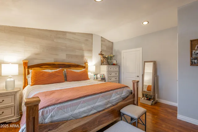 a bedroom with a bed and wooden floor