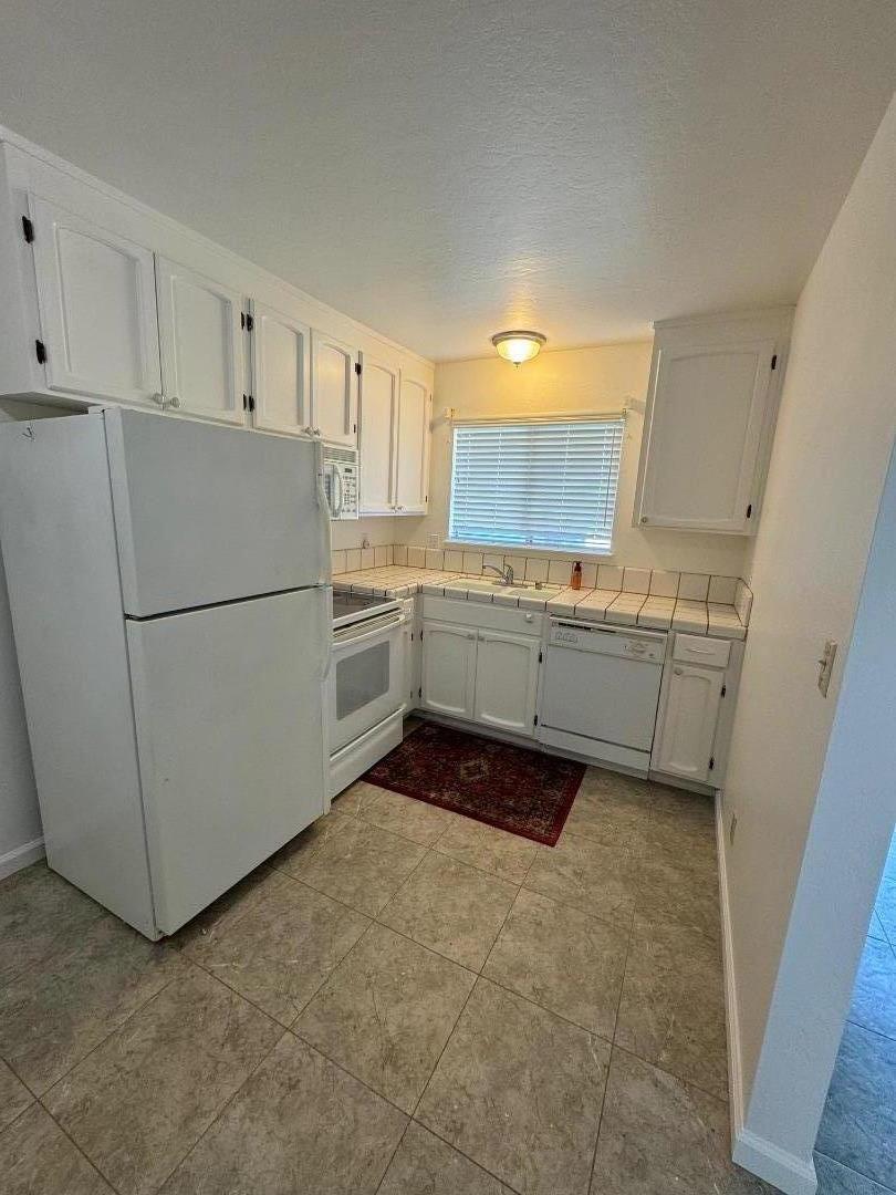 1261 Juniper Drive, Unit 12 Gilroy, CA 95020 - Photo 6 of 9 a kitchen with a refrigerator sink stove and cabinets
