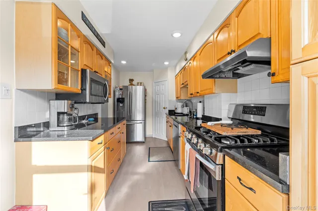 a kitchen with stainless steel appliances granite countertop a stove top oven a sink and dishwasher