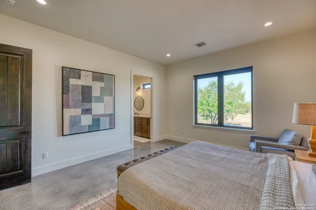 a bedroom with a bed and a large window