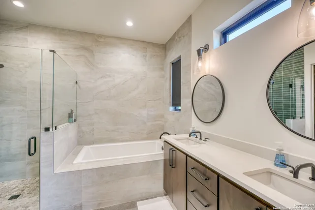 a bathroom with a granite countertop sink mirror and bathtub