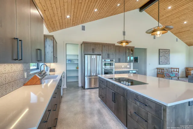 a kitchen with stainless steel appliances granite countertop a sink and a refrigerator