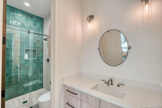 a bathroom with a sink a toilet and shower