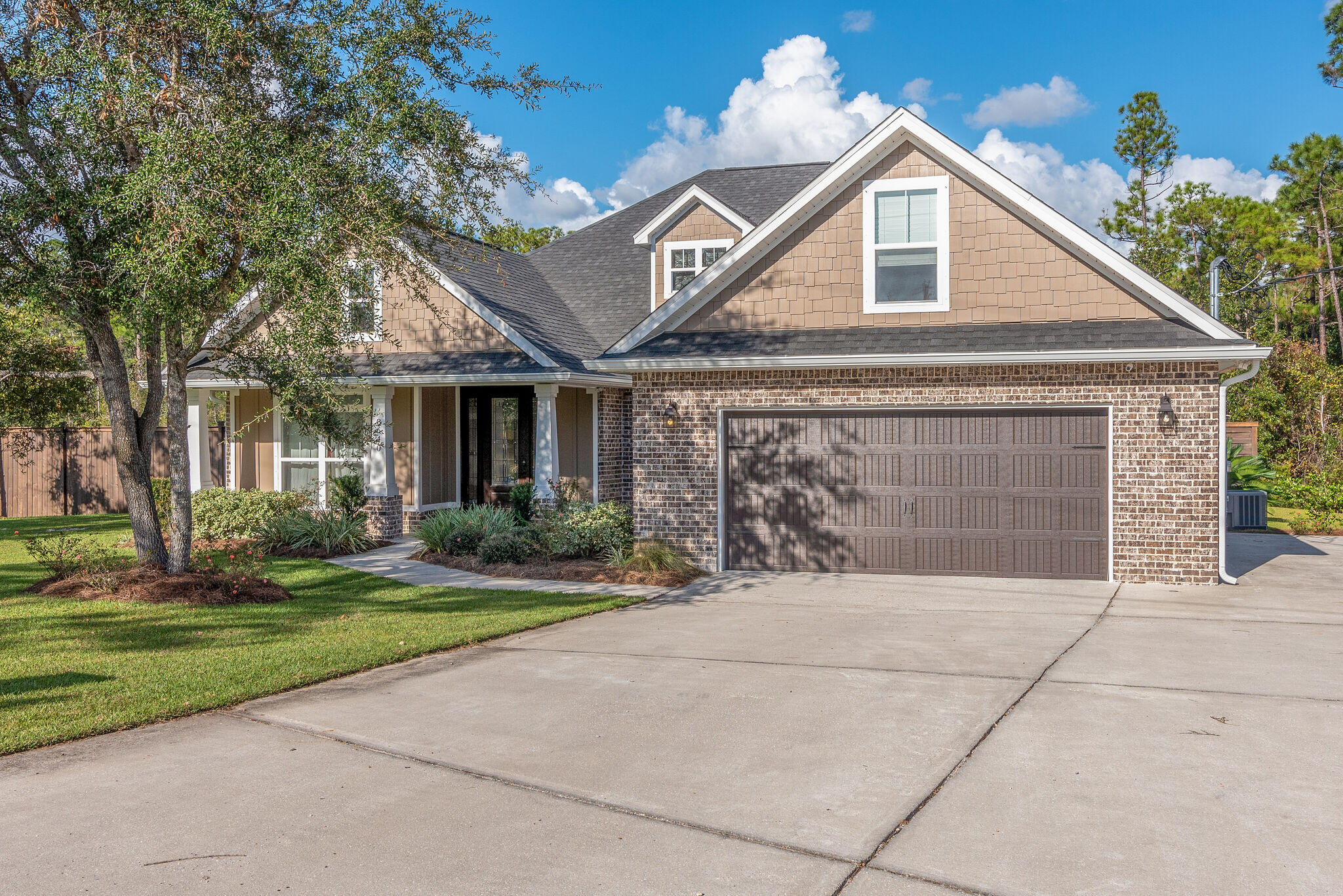 8640 Sand Pine Drive Navarre, FL 32566 - Photo 2 of 58 a front view of a house with a yard and garage