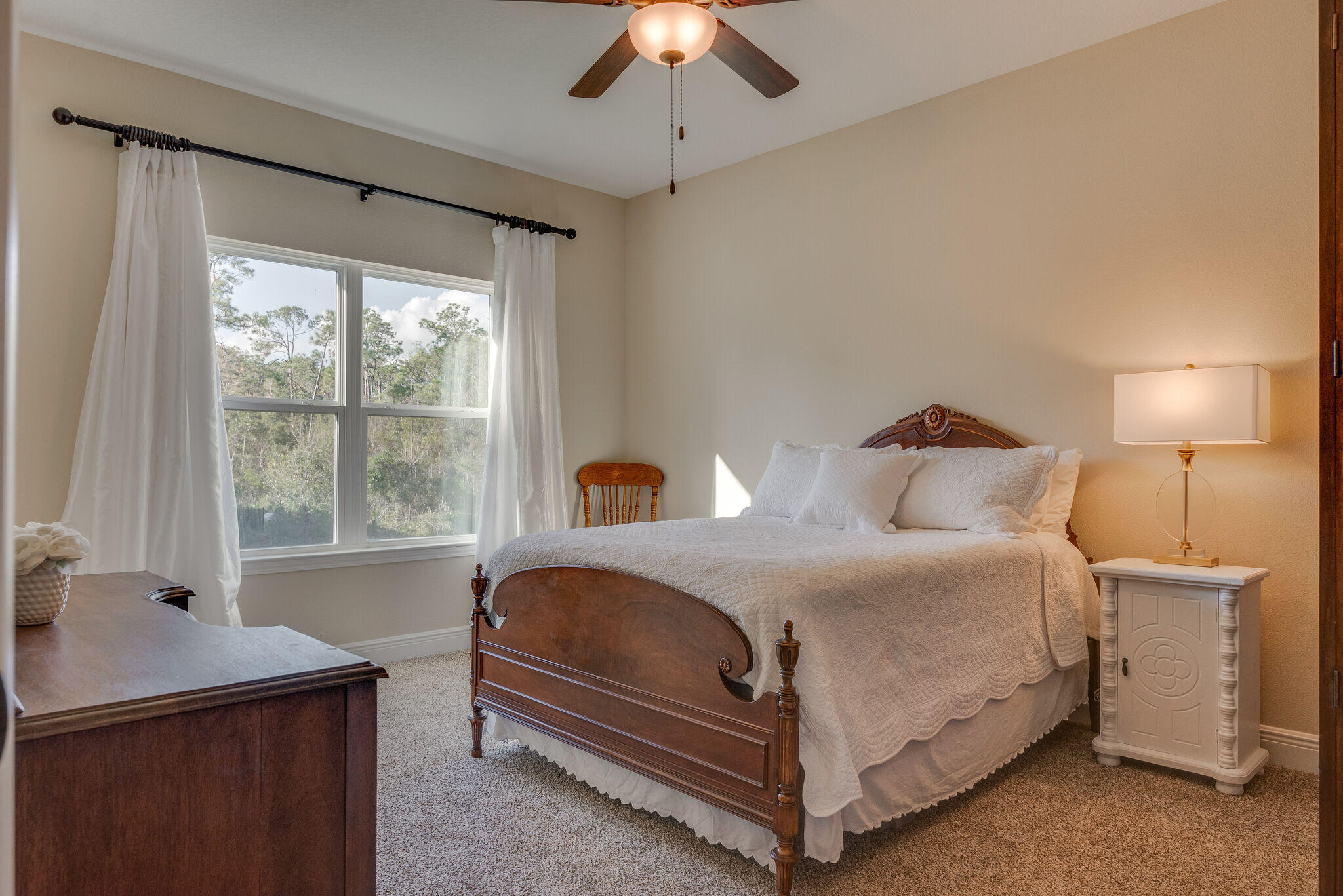 8640 Sand Pine Drive Navarre, FL 32566 - Photo 30 of 58 a bedroom with a bed and a chandelier