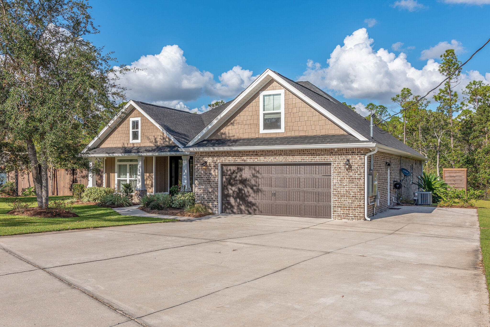 8640 Sand Pine Drive Navarre, FL 32566 - Photo 3 of 58 a front view of a house with a yard and garage