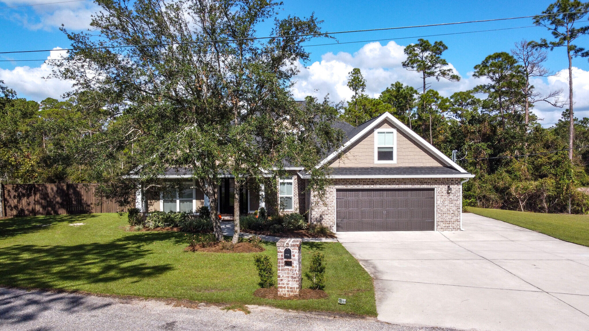 8640 Sand Pine Drive Navarre, FL 32566 - Photo 44 of 58 a front view of a house with a yard and garage