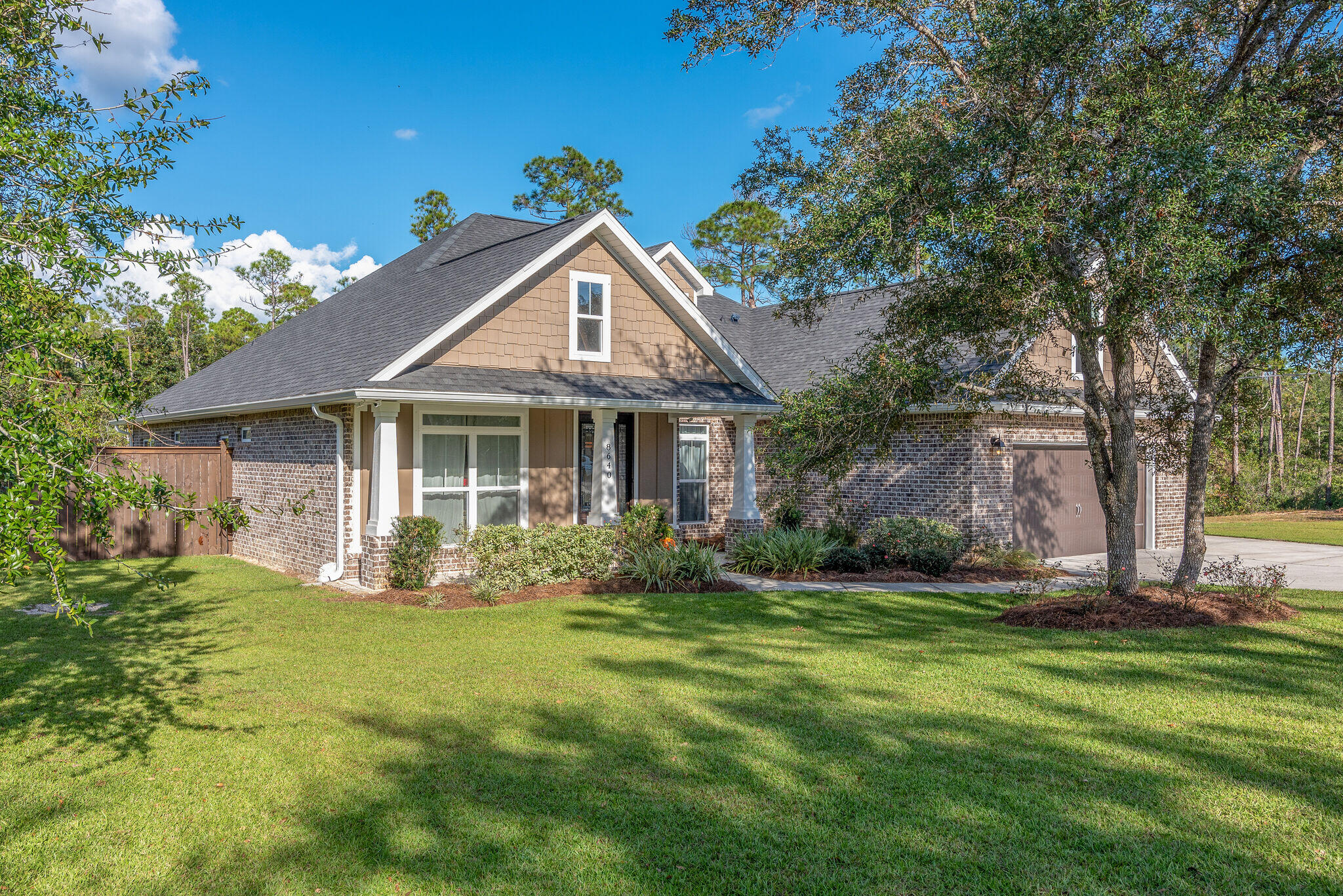 8640 Sand Pine Drive Navarre, FL 32566 - Photo 5 of 58 a front view of a house with garden