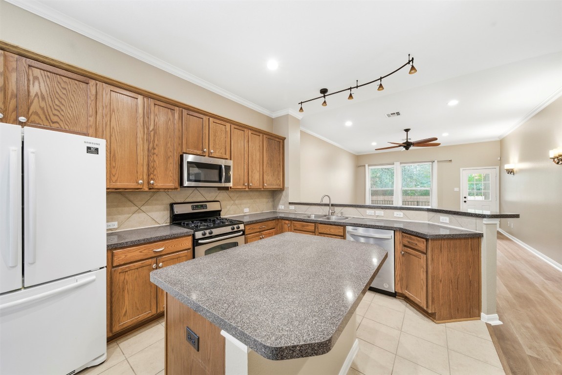 2989 Peacemaker Street Round Rock, TX 78681 - Photo 11 of 40 a kitchen with stainless steel appliances granite countertop a sink stove and refrigerator
