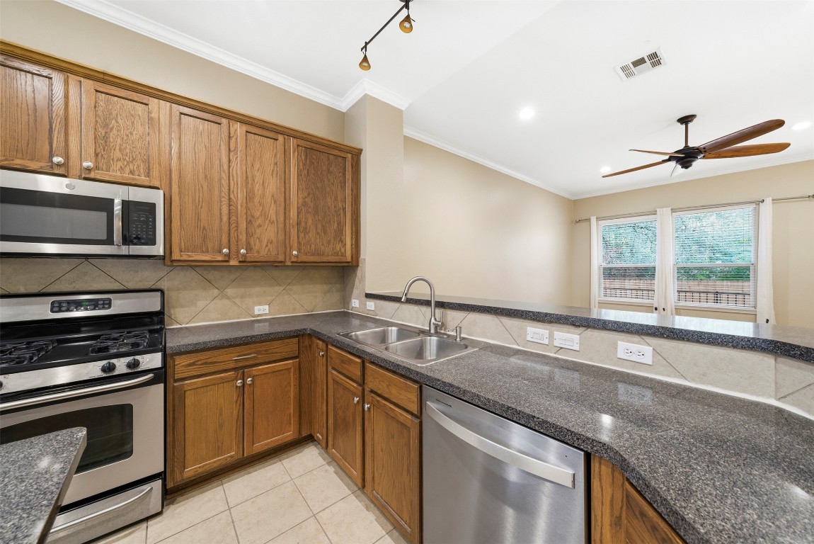 2989 Peacemaker Street Round Rock, TX 78681 - Photo 12 of 40 a kitchen with stainless steel appliances granite countertop a sink a stove and a microwave
