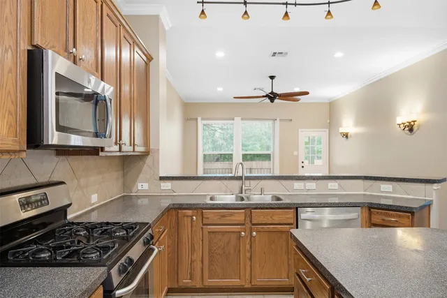 a kitchen with stainless steel appliances granite countertop a sink stove and cabinets