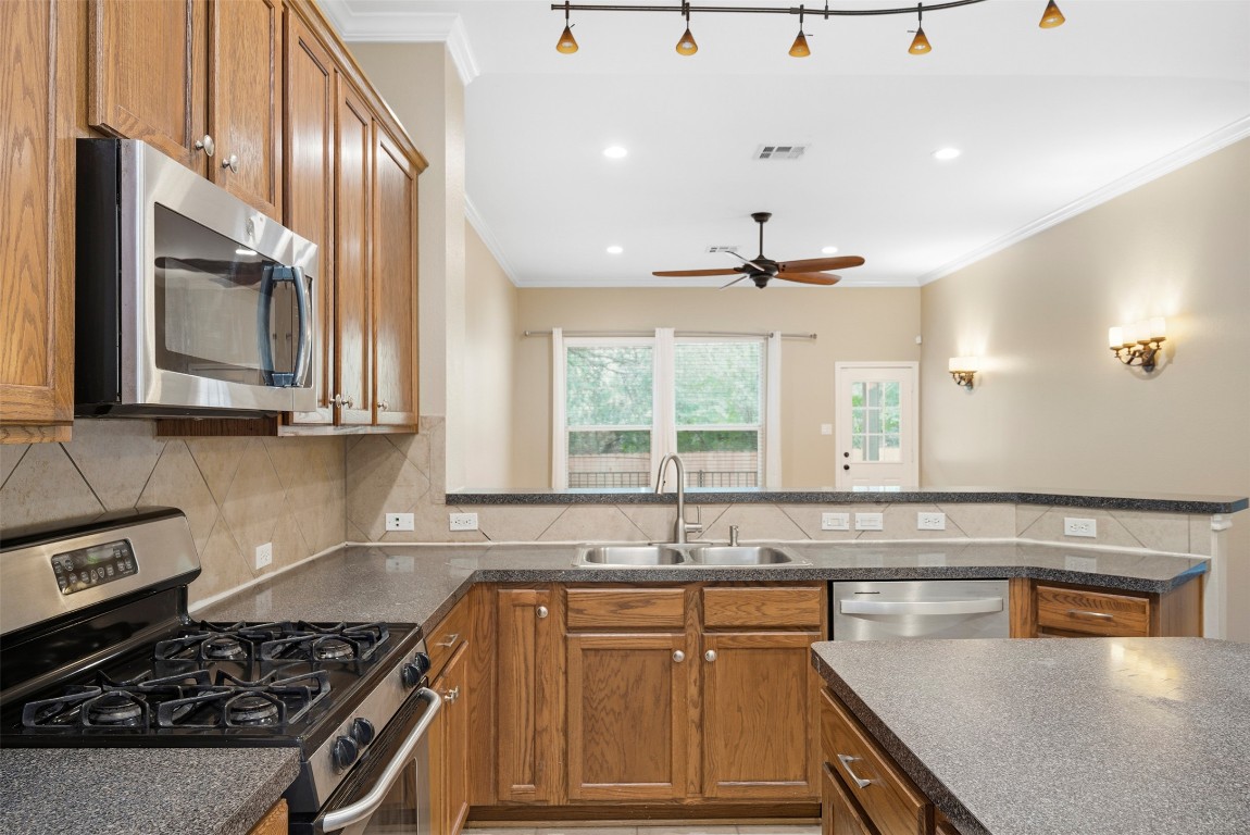 2989 Peacemaker Street Round Rock, TX 78681 - Photo 13 of 40 a kitchen with stainless steel appliances granite countertop a sink stove and cabinets