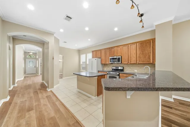 a kitchen with stainless steel appliances granite countertop a sink stove and cabinets