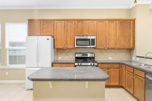 a kitchen with stainless steel appliances granite countertop a stove a sink and a microwave