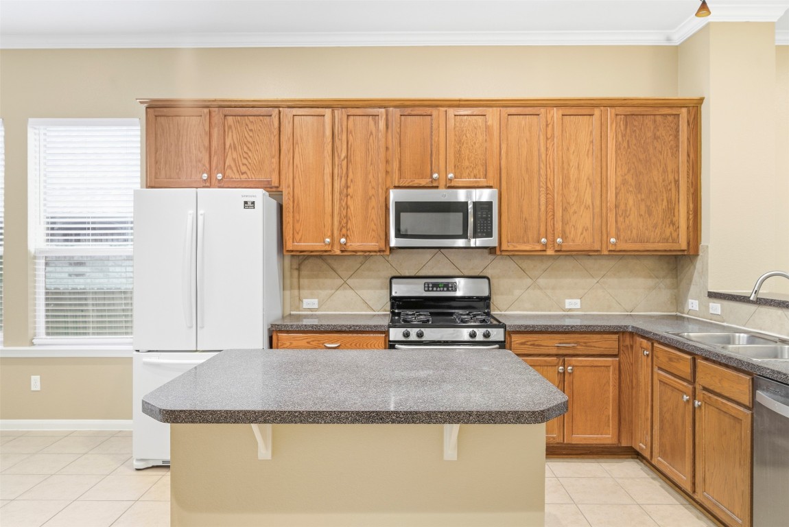2989 Peacemaker Street Round Rock, TX 78681 - Photo 10 of 40 a kitchen with stainless steel appliances granite countertop a stove a sink and a microwave