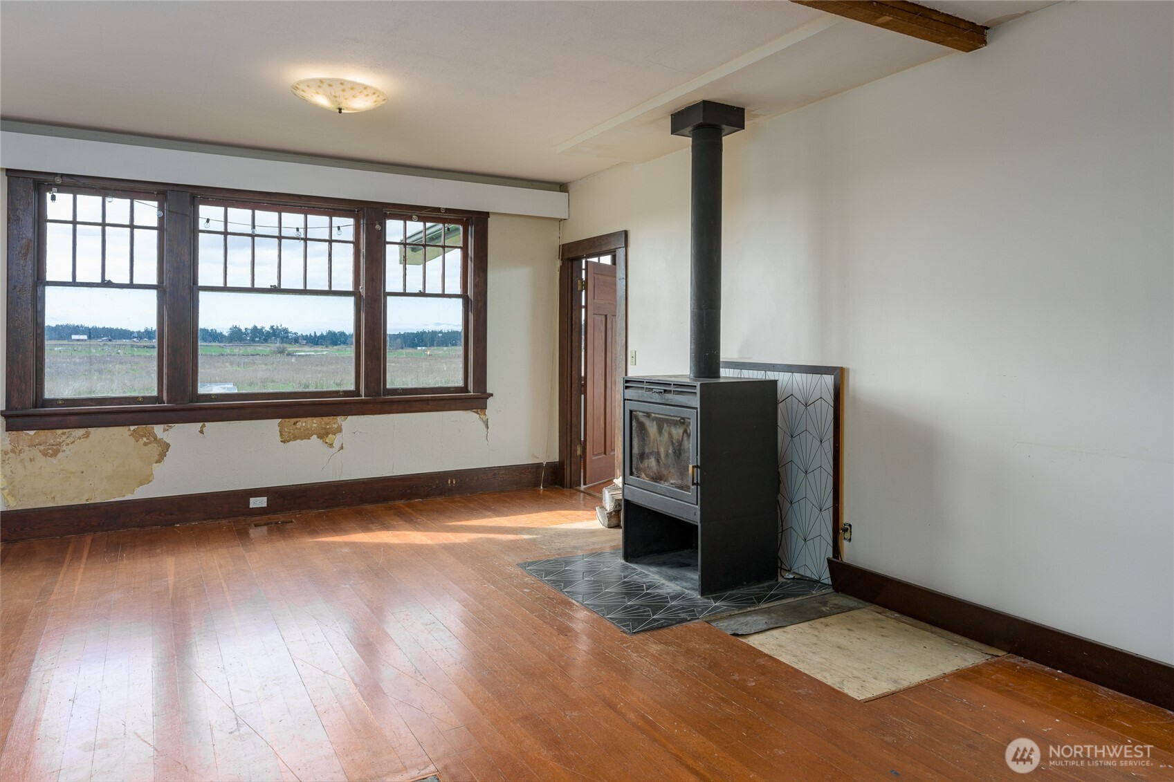 5625 Fisherman Bay Road Lopez Island, WA 98261 - Photo 24 of 40 an empty room with wooden floor and windows