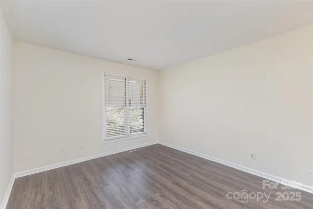 an empty room with wooden floor and window