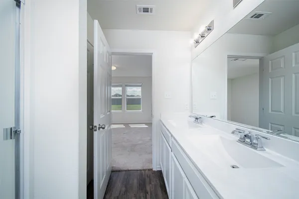 a white toilet sitting next to a bathroom sink and vanity