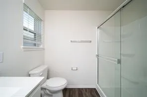 a white toilet sitting next to a bathroom sink and vanity