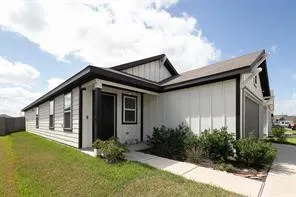 a backyard of a house with plants and barbeque oven