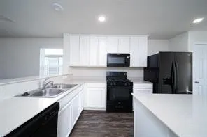a kitchen with a refrigerator sink and white cabinets