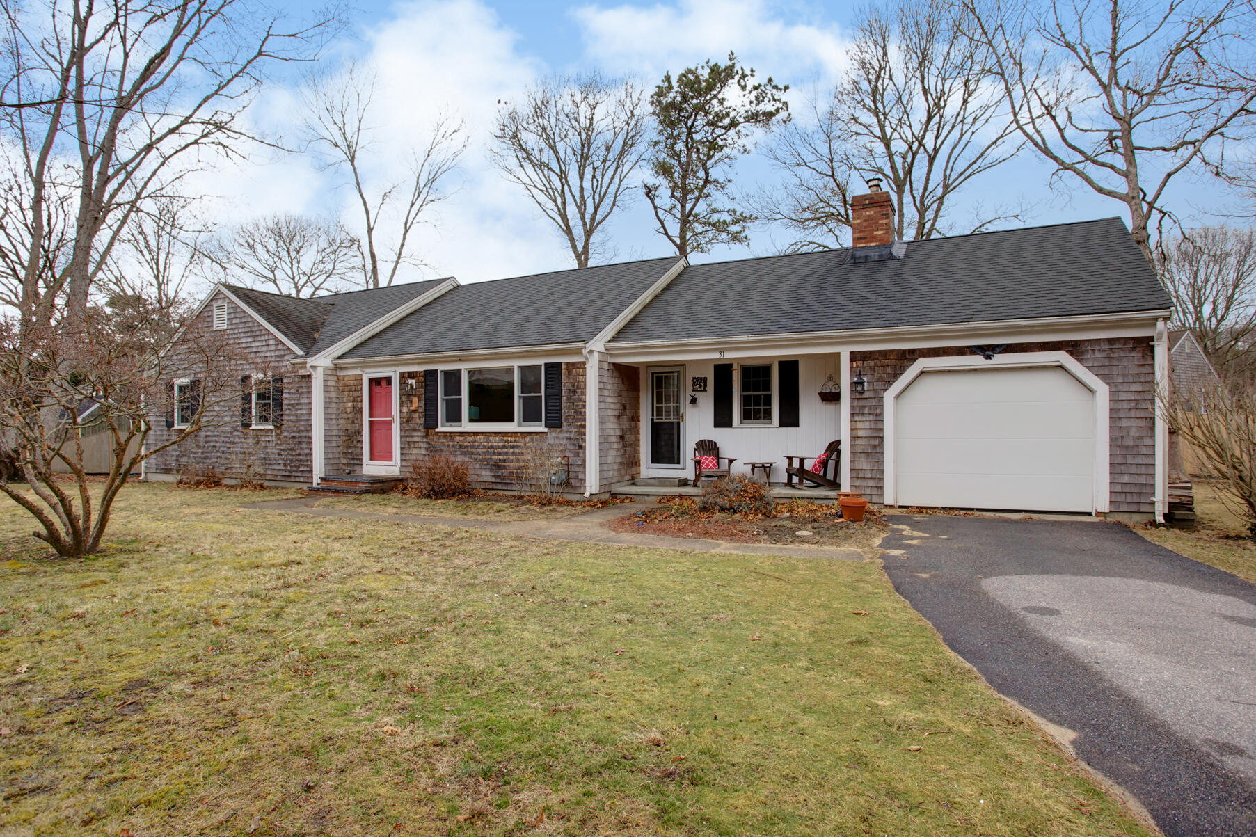 a view of a house with a yard and large tree