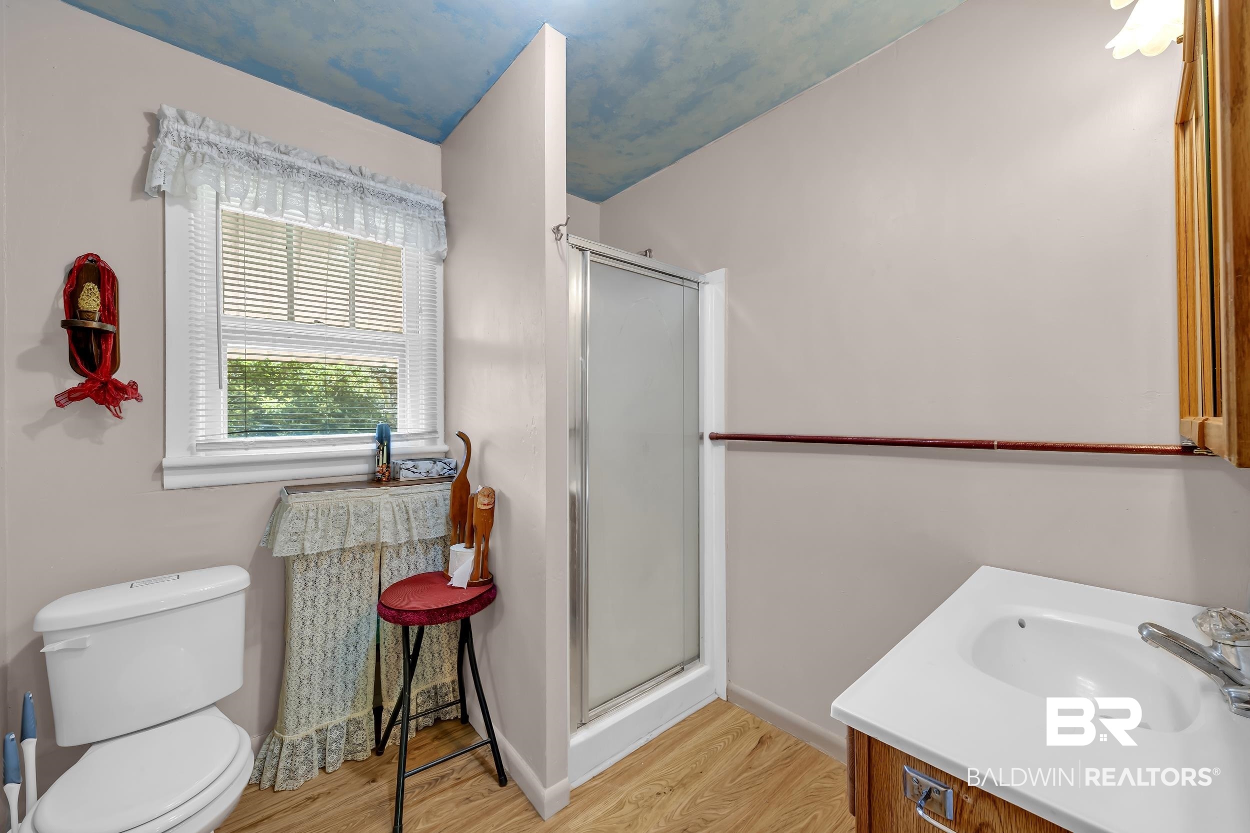 304 West Myrtle Avenue Foley, AL 36535 - Photo 13 of 29 Bathroom featuring a white toilet, wood-finish flooring, and a white single-sink vanity with a wood-finish cabinet
