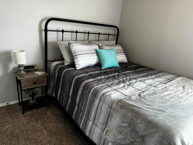 a bed sitting in a bedroom next to a lamp