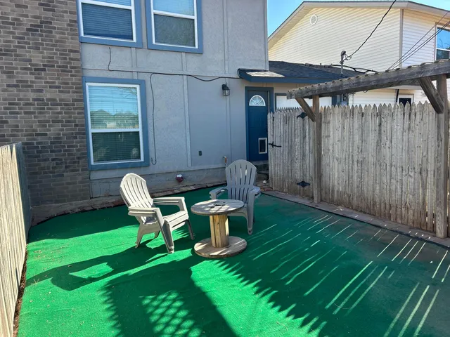 a view of a backyard with table and chairs and a barbeque