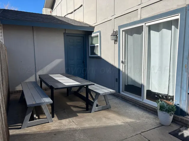 a backyard of a house with table and chairs