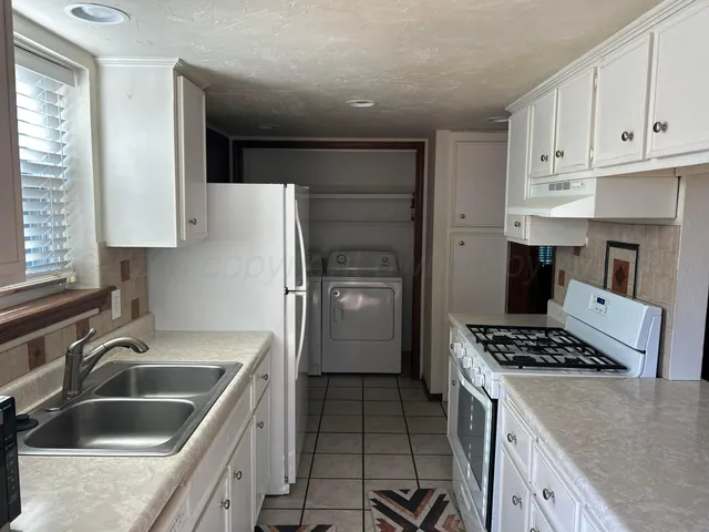 a kitchen that has a sink and a stove in it