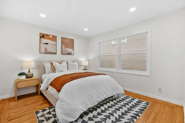 a bedroom with a bed and wooden floor