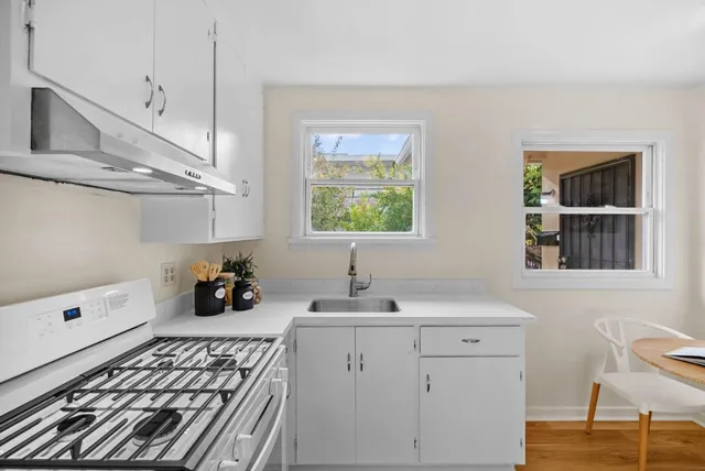 a view of a kitchen with refrigerator and white cabinets