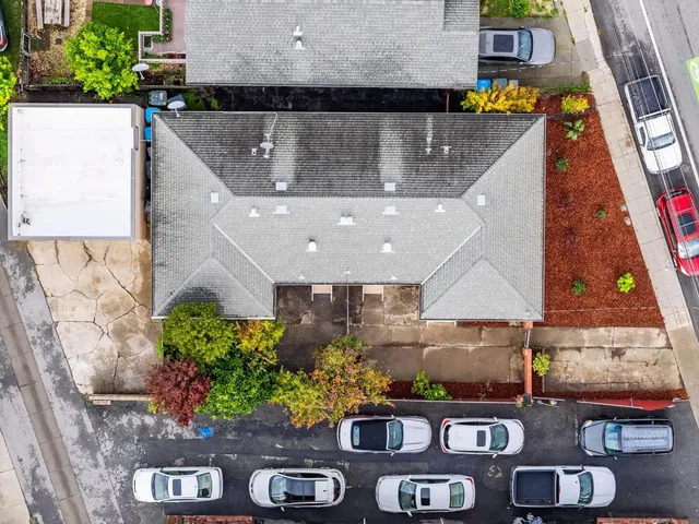 a view of a house with a barbeque and wooden fence