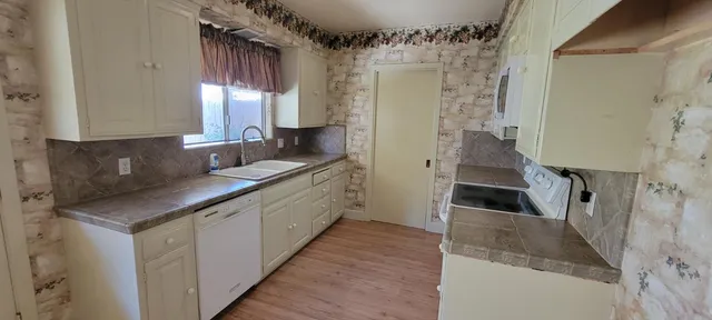 a kitchen with granite countertop a sink and a refrigerator
