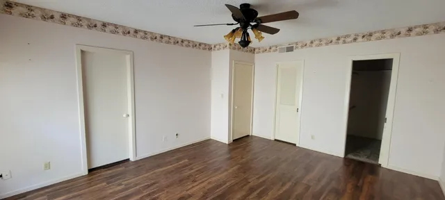 a view of empty room with wooden floor