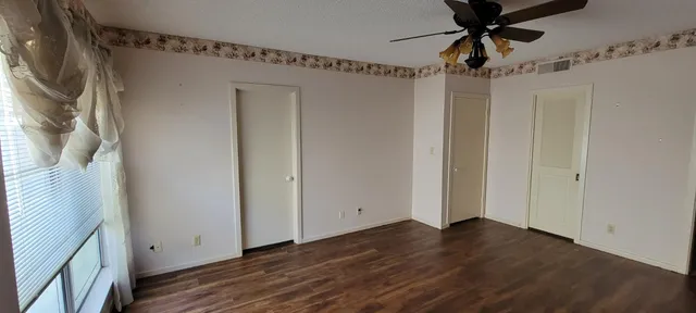 a view of a room with wooden floor and fan