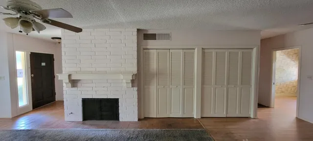 a view of a livingroom with wooden floor and a fireplace