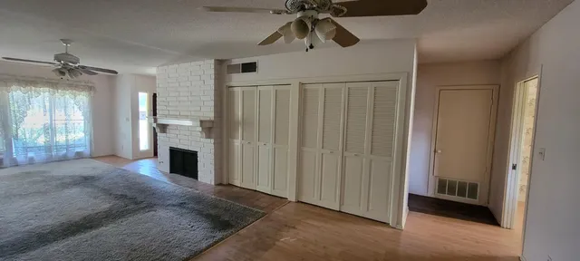 a view of empty room with fireplace and fan