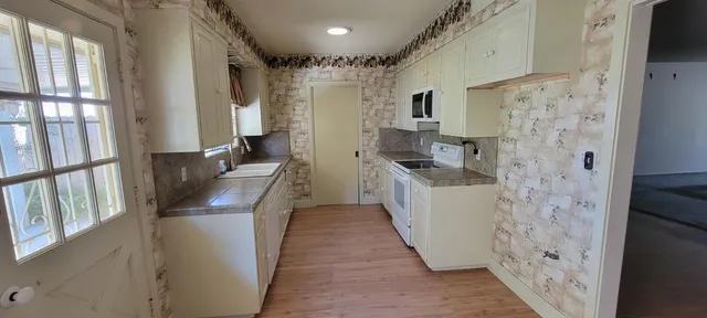 a hallway with a white stove a washer and dryer