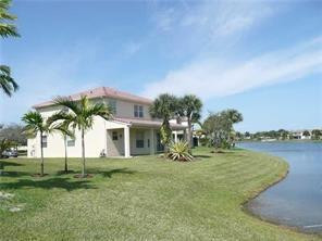 a view of a house with a yard and palm trees