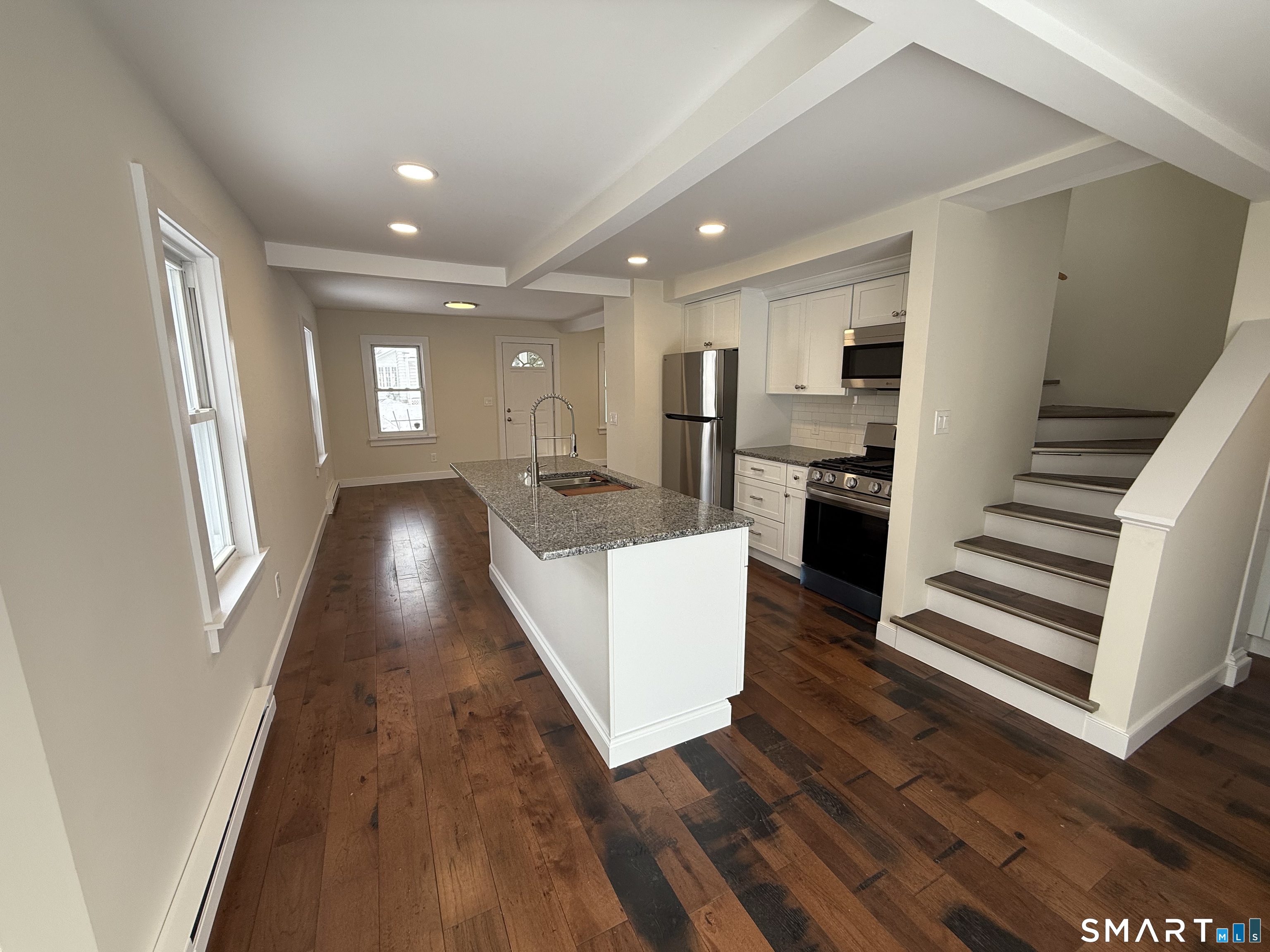98 East Elm Street Torrington, CT 06790 - Photo 5 of 10 a living room with stainless steel appliances furniture a fireplace and wooden floor