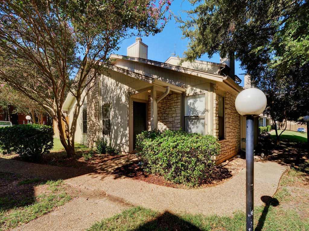 a front view of a house with a yard and potted plants