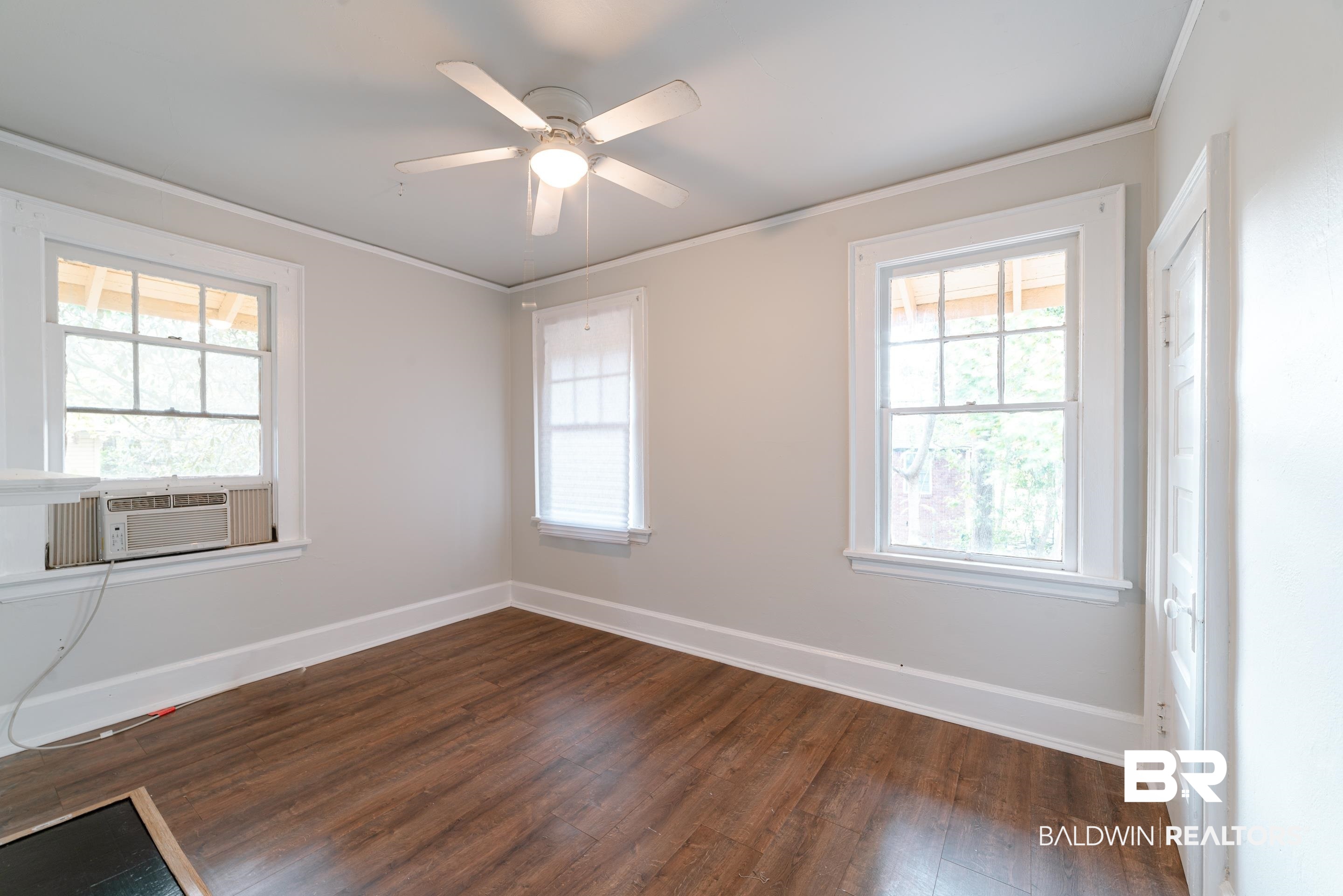 312 1st Street Mobile, AL 36611 - Photo 17 of 29 Empty room featuring dark hardwood / wood-style flooring, cooling unit, ceiling fan, and a wealth of natural light