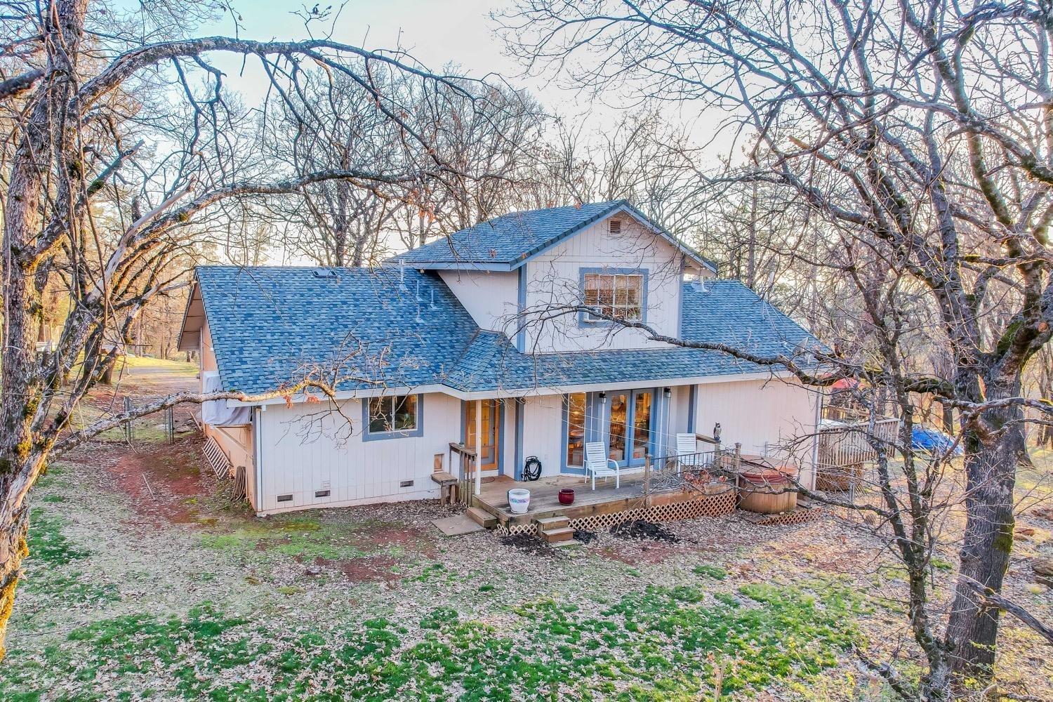 5271 Caprine Road Greenwood, CA 95635 - Photo 27 of 39 a backyard of a house with table and chairs under an umbrella